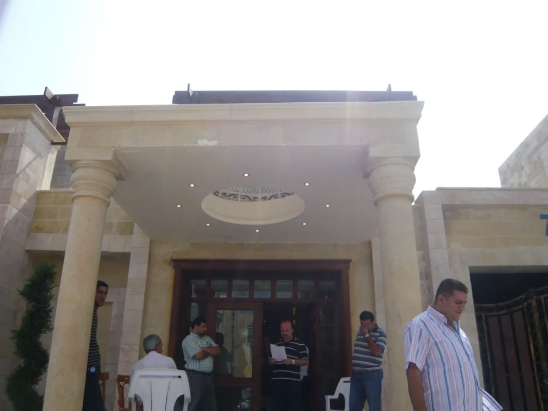 مدخل فيلا فاخرة في الأردن مع تشطيبات حجر طبيعي وأعمدة كلاسيكية