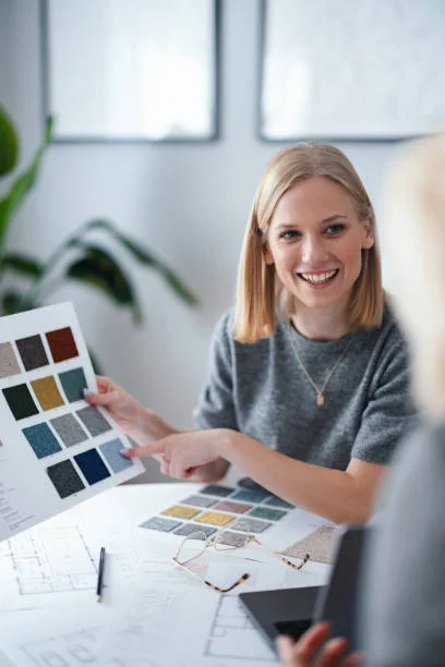 اختيار مصمم داخلي مناسب يعرض مخطط تصميم ثلاثي الأبعاد على العميل أثناء اجتماع